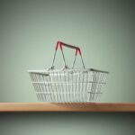 Red-handled metal shopping basket on wooden shelf, symbolizing consumer culture.