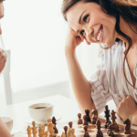 Couple enjoying a cozy chess game with coffee, focused man and joyful woman.