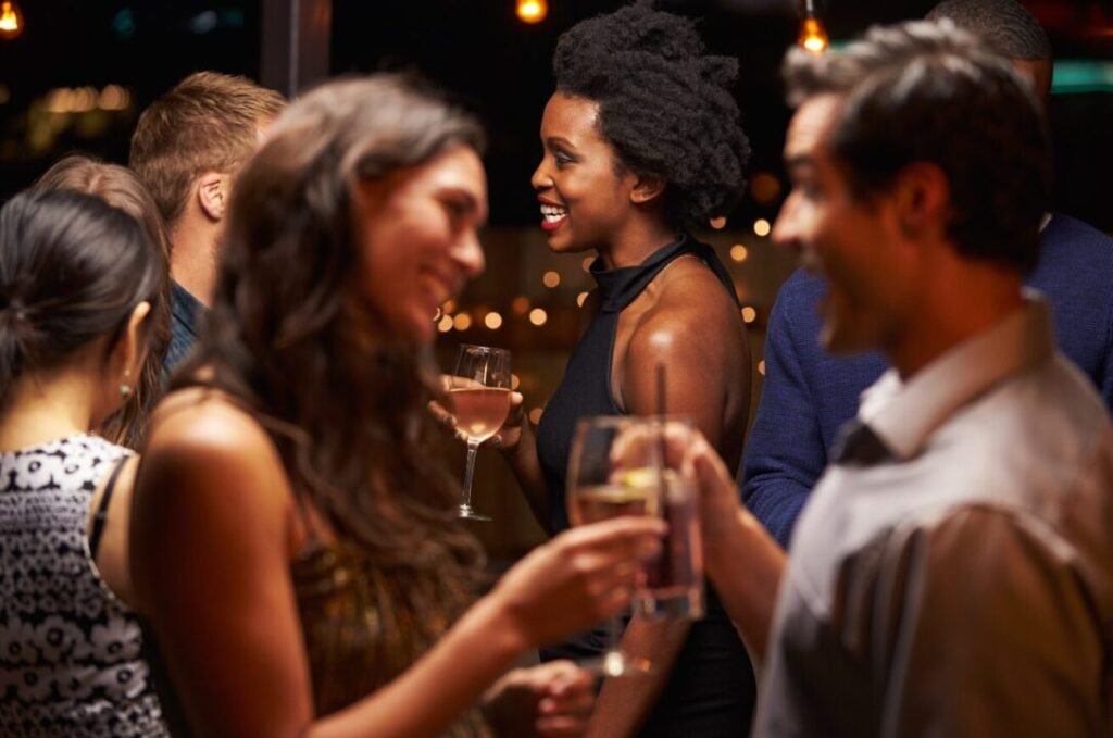 People socializing at a party with drinks in their hands.