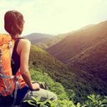 Woman in nature: Serene moment amidst lush green mountains, looking out in tranquility.