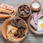 Hearty variety of cooked proteins on rustic wooden table.