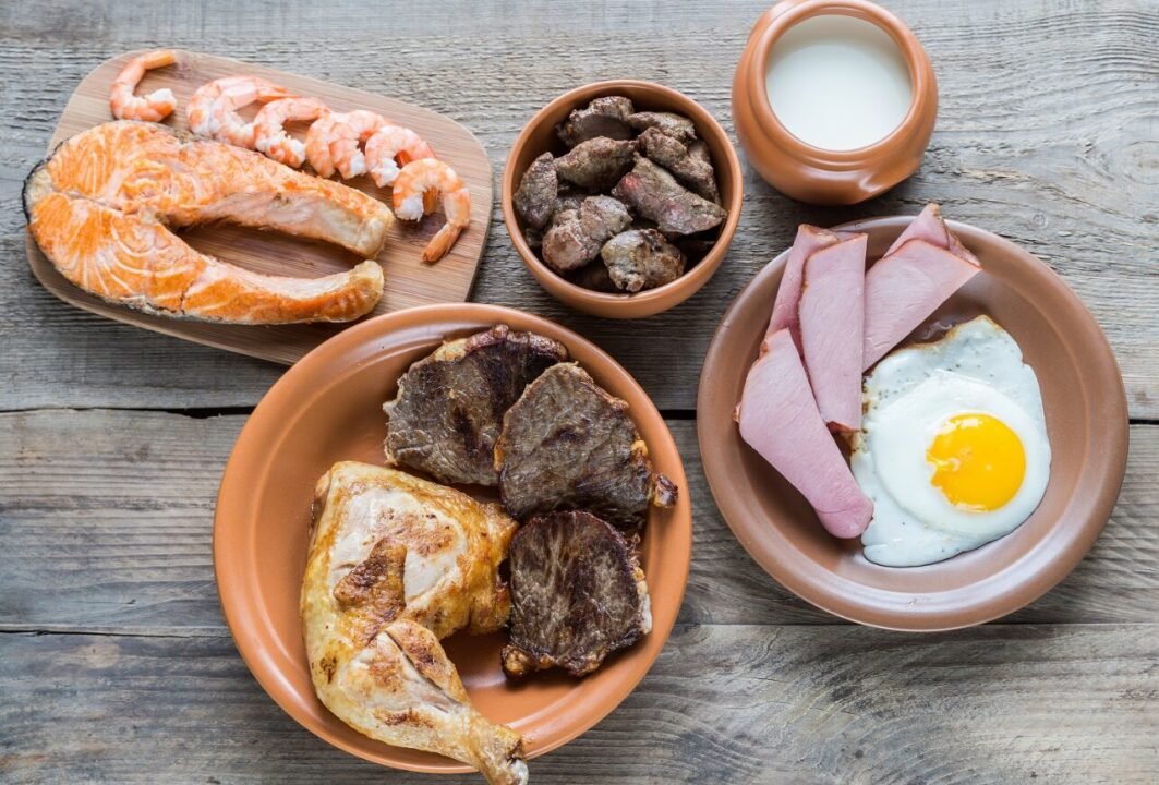 Hearty variety of cooked proteins on rustic wooden table.