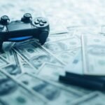 Modern video game controller amidst scattered US dollar bills, illustrating the gaming industrys economic impact.