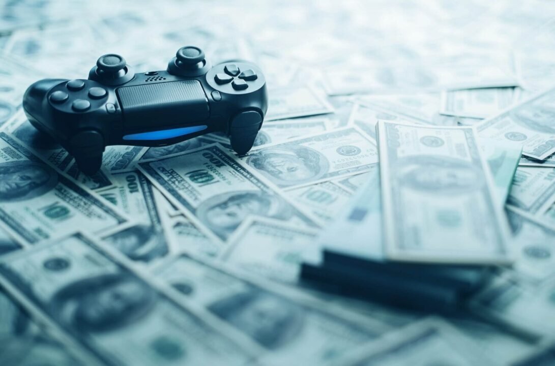 Modern video game controller amidst scattered US dollar bills, illustrating the gaming industrys economic impact.
