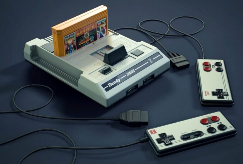 A vintage Dendy video game console with a game cartridge inserted on top and two wired controllers beside it, all placed on a dark surface.