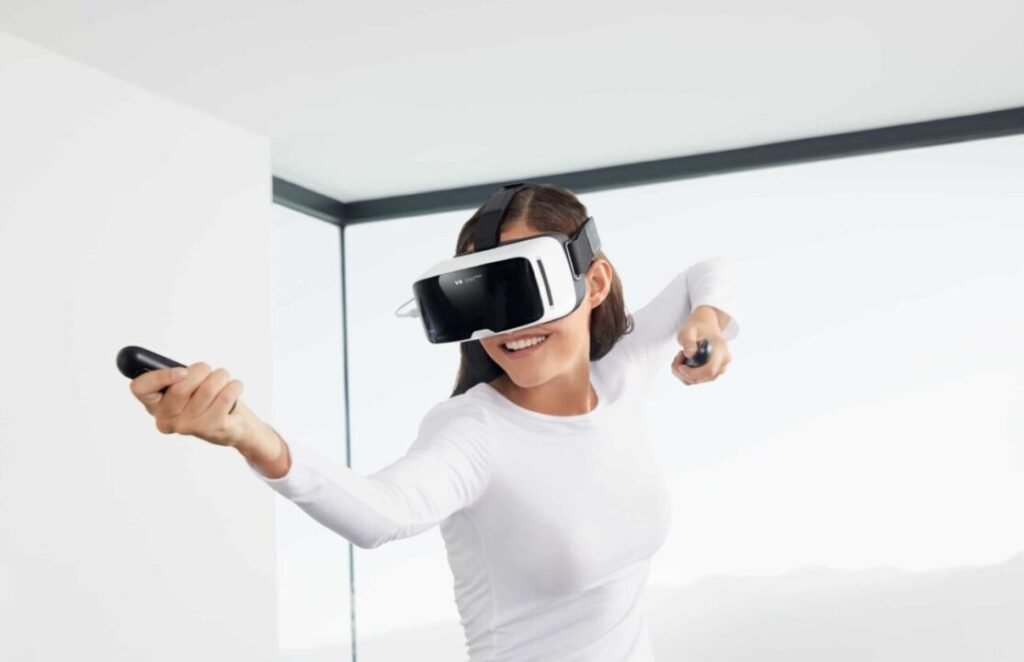 A smiling person wearing a virtual reality headset, actively using handheld controllers in a bright, minimalist room.