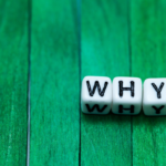 Curious Dice on Green: Three white dice spell WHY, inviting introspection and curiosity.