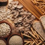 Nutritious whole grain bread, pasta, oats, and grains on wooden surface.
