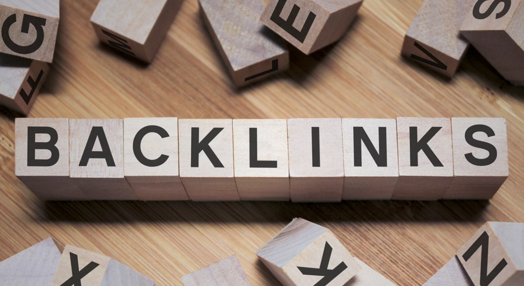 Wooden blocks on a table spelling out the word "BACKLINKS" with scattered blocks around them.