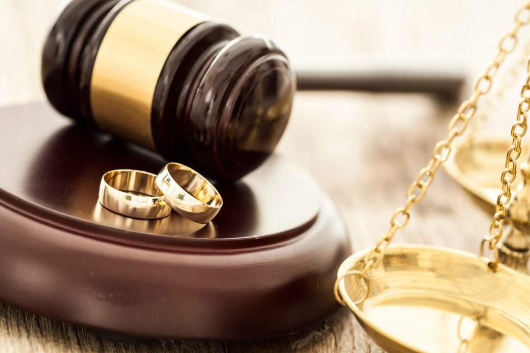 Legal decision: wedding rings, gavel, scales - symbolizing marriage or divorce proceedings in court.