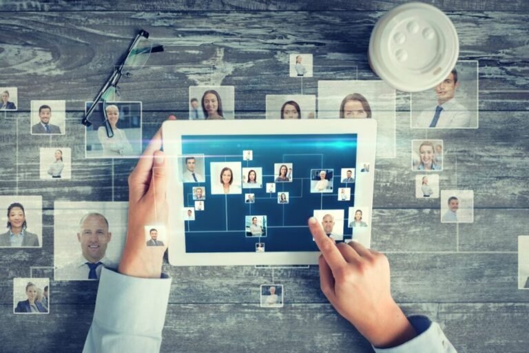 Connected workspace with digital and personal elements: tablet, photos, eyeglasses, coffee cup.