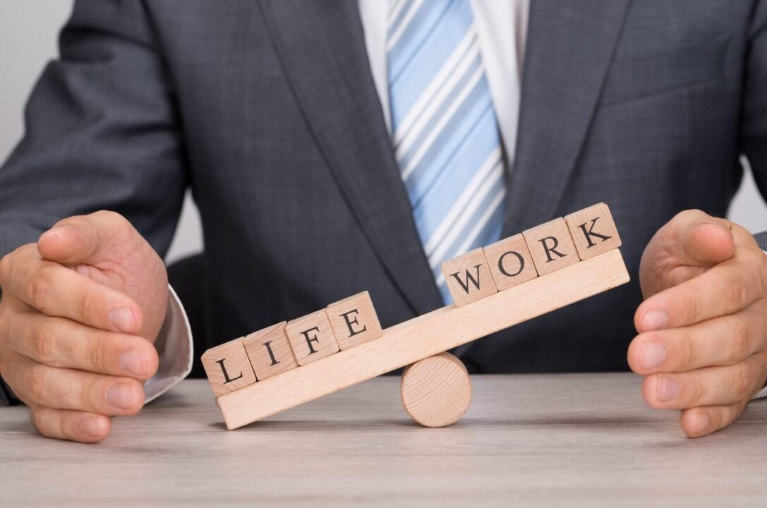 Balancing work-life with a seesaw metaphor: wooden blocks spell LIFE and WORK.