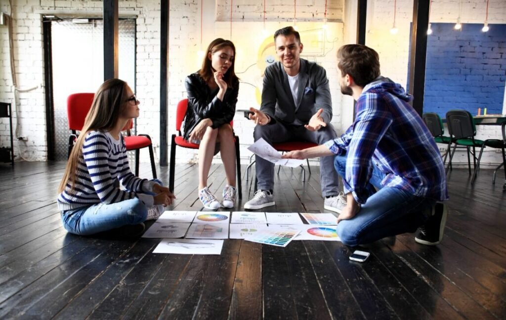 Young professionals brainstorming in modern rustic workspace with documents and charts.