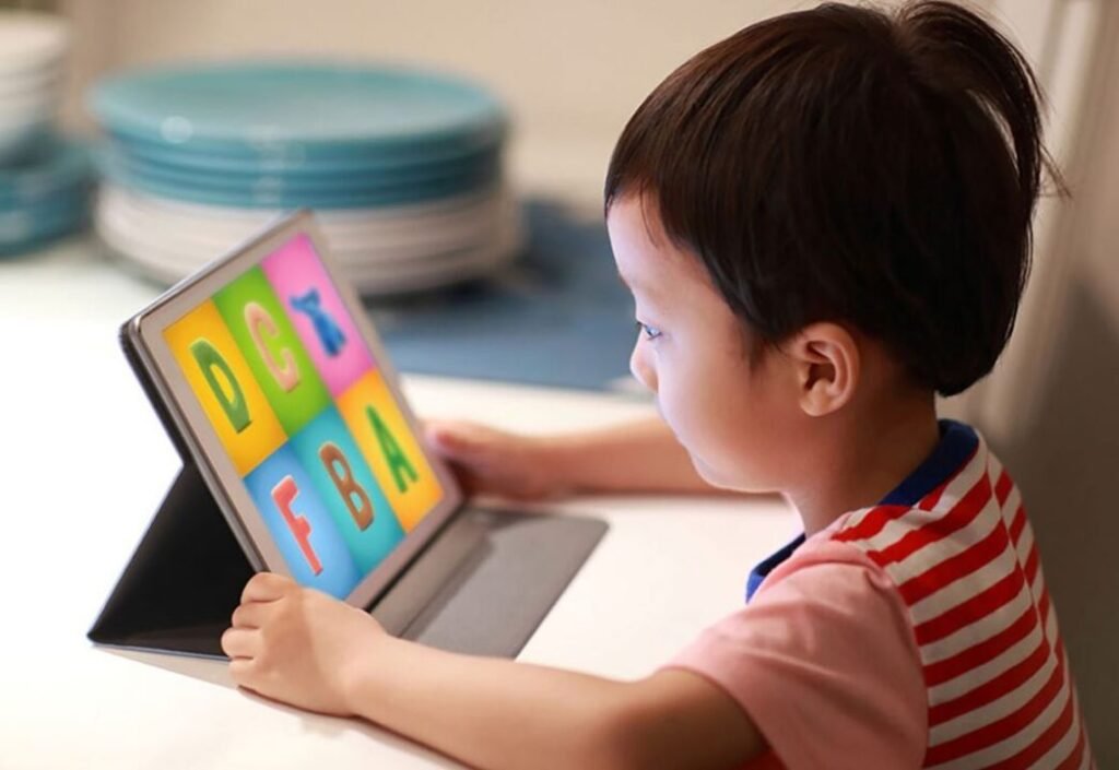 Child using a tablet with colorful alphabet letters displayed on the screen.