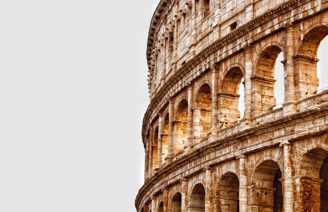 Close-up of the Colosseum showing the detailed architecture of the arched openings and weathered stone walls.