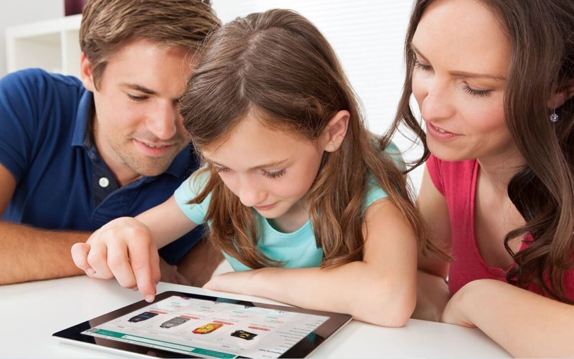 A man, a woman, and a young girl are sitting together, looking at a tablet. The girl is using her finger to navigate the screen while the adults attentively watch.