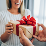 Heartwarming gift exchange between woman and older adult in cozy setting.