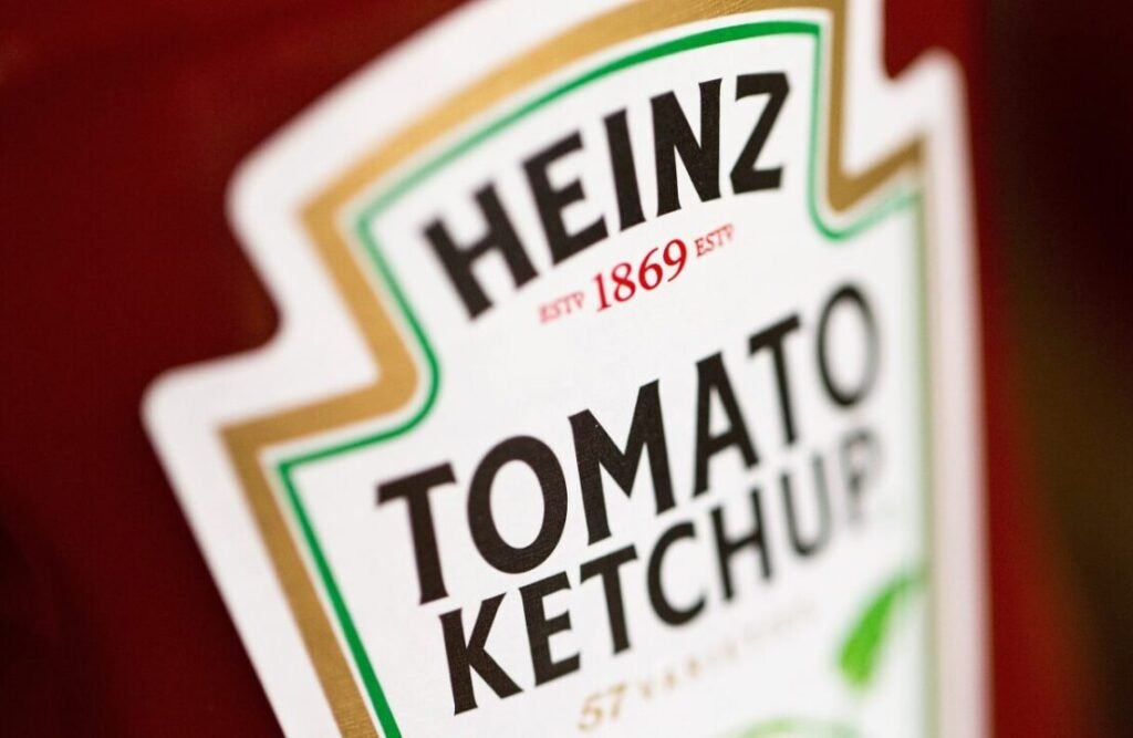 Close-up of a Heinz Tomato Ketchup bottle label, focusing on the logo and text.