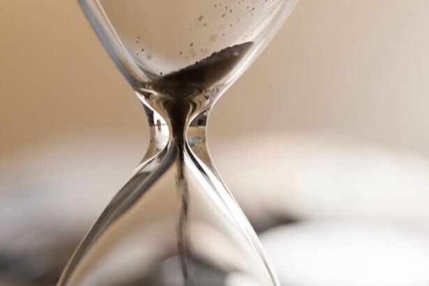 Close-up of an hourglass with sand flowing through the narrow middle.