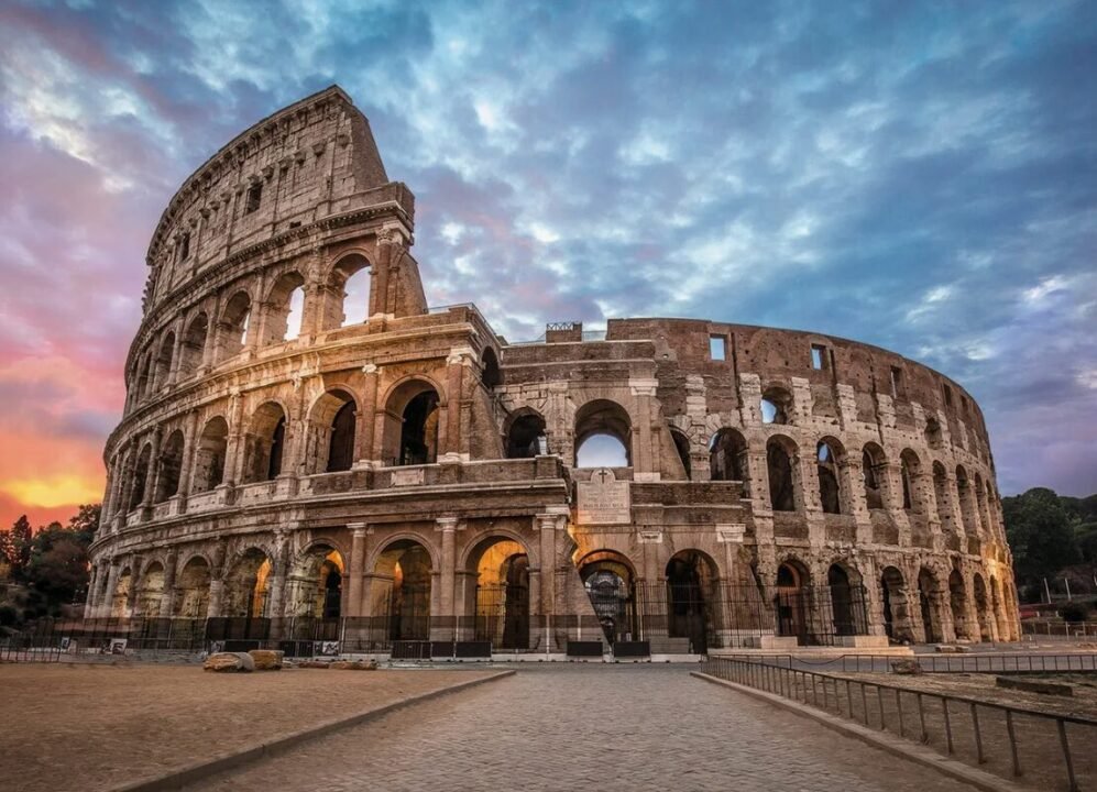 The Colosseum in Rome at sunset with a dramatic sky.