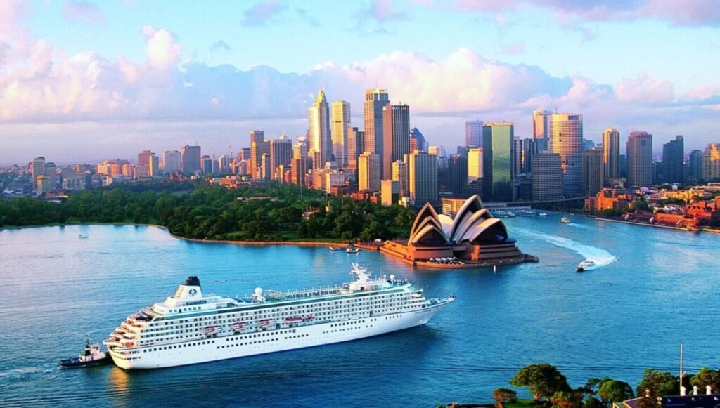 Aerial view of Sydney Harbour featuring the Sydney Opera House, a cruise ship, and the city skyline during early morning light.