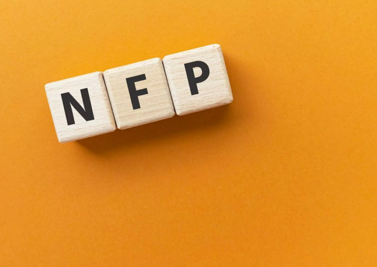 Three wooden blocks spell NFP on vibrant orange background for creative interpretation.