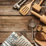 Rustic kitchen utensils on wooden surface for cozy home cooking scene.