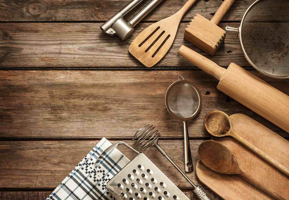 Rustic kitchen utensils on wooden surface for cozy home cooking scene.