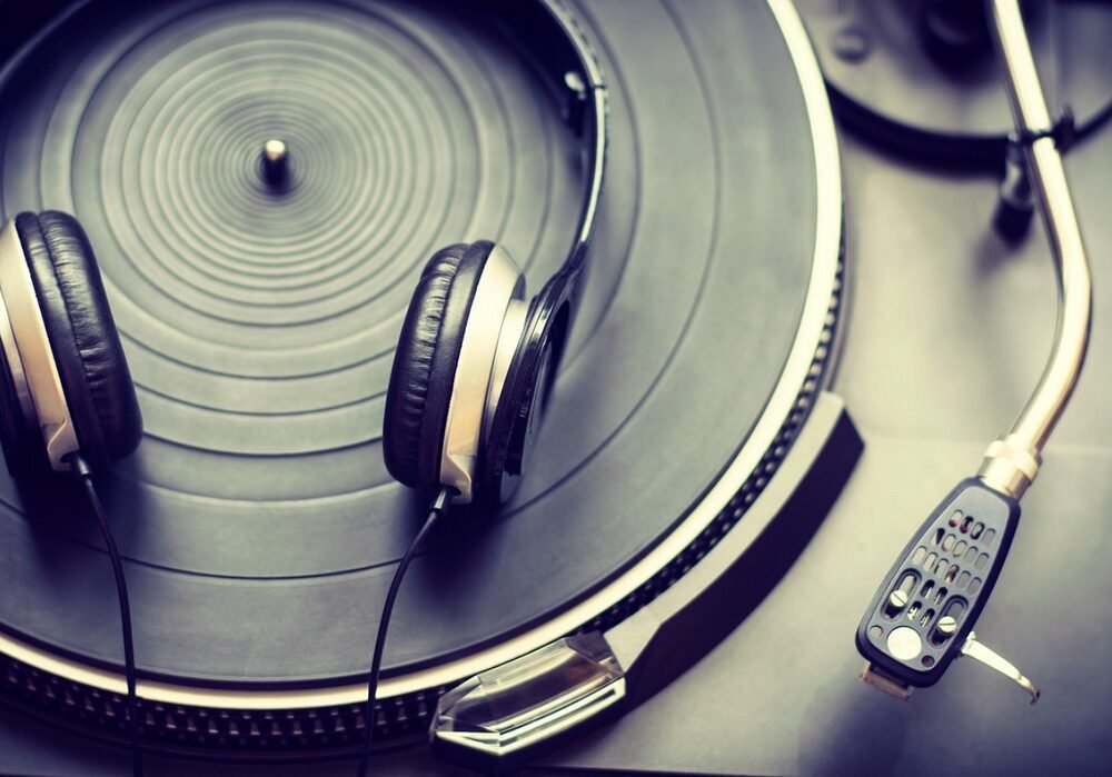 Analog vinyl turntable with headphones for immersive music listening experience.