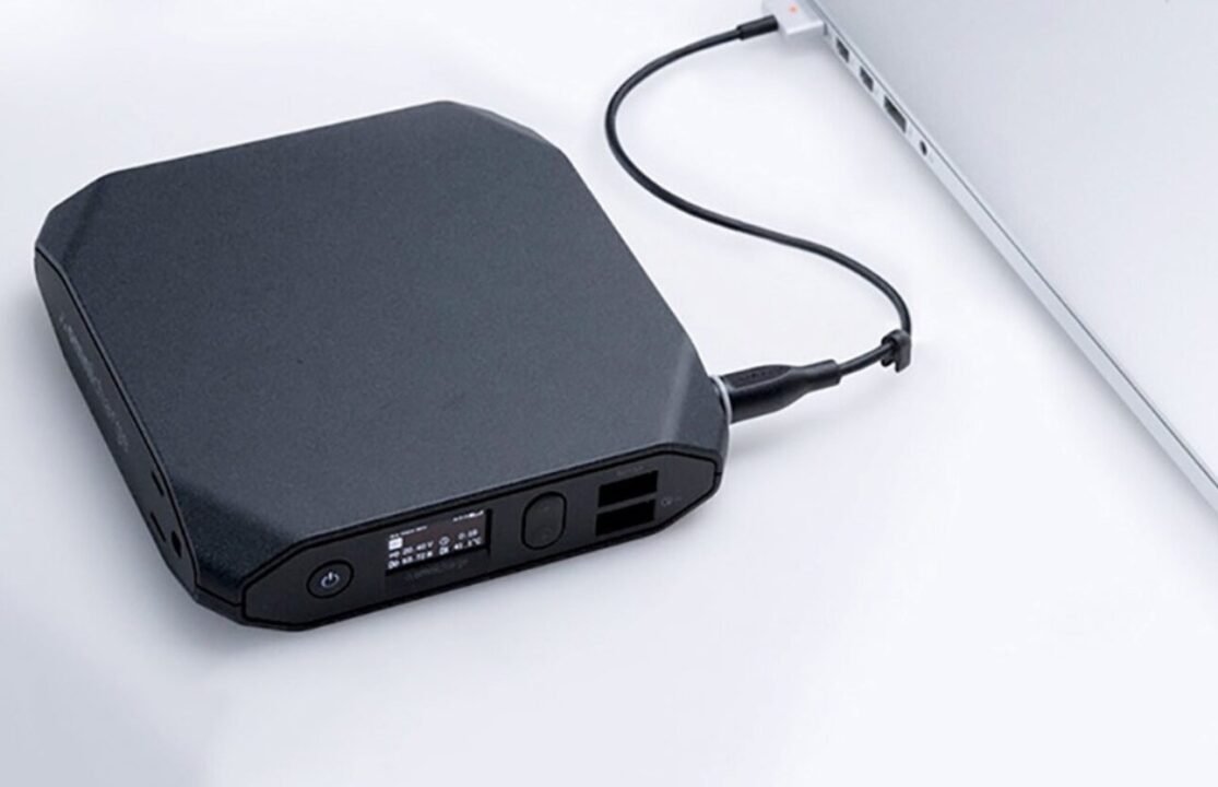 Sleek matte black external hard drive with USB Type-C port, connected to laptop.