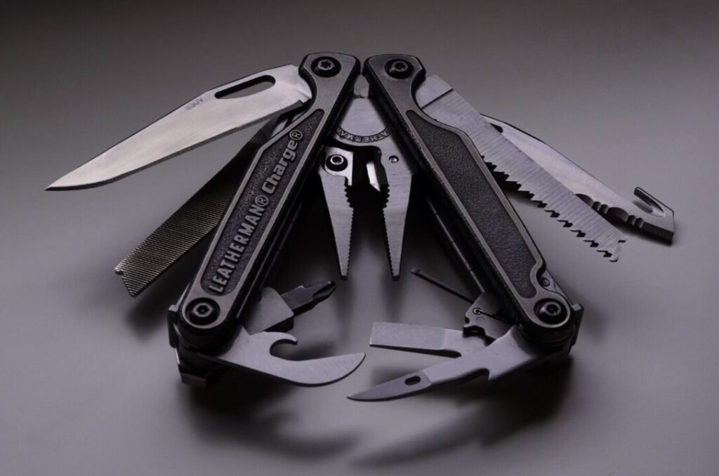 Multitool with various tools extended including knife, saw, pliers, and scissors, displayed on a grey background.