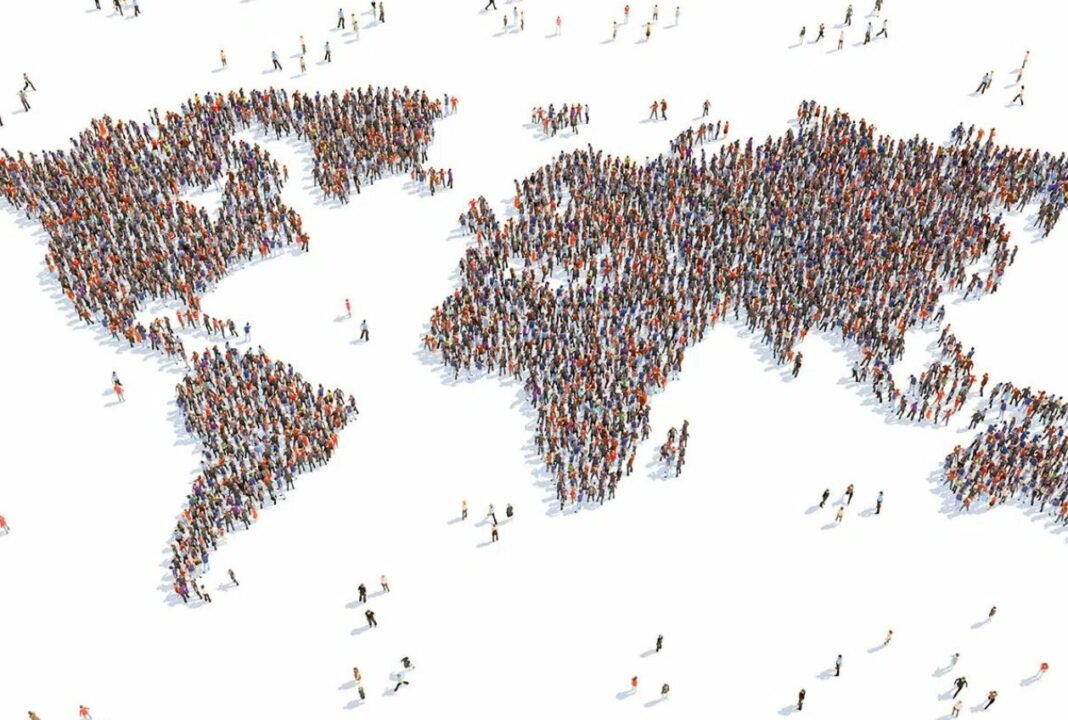 A large group of people arranged to form the shape of a world map on a white background.
