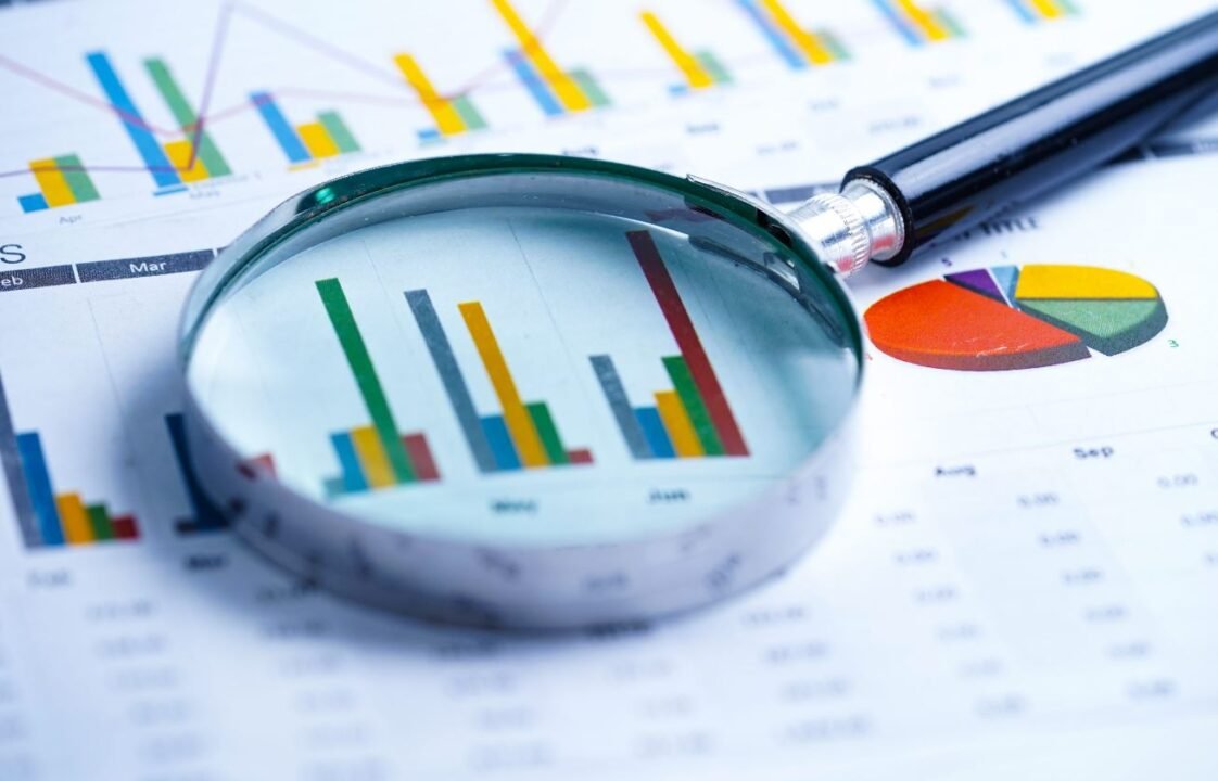 Magnifying glass over charts and graphs on a document.