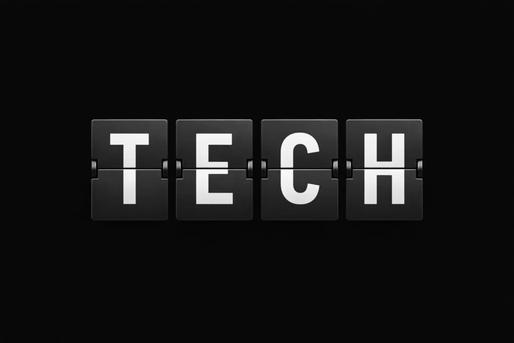 a mechanical split-flap display shows the word “TECH” .Editorial, cultural magazine aesthetic.
